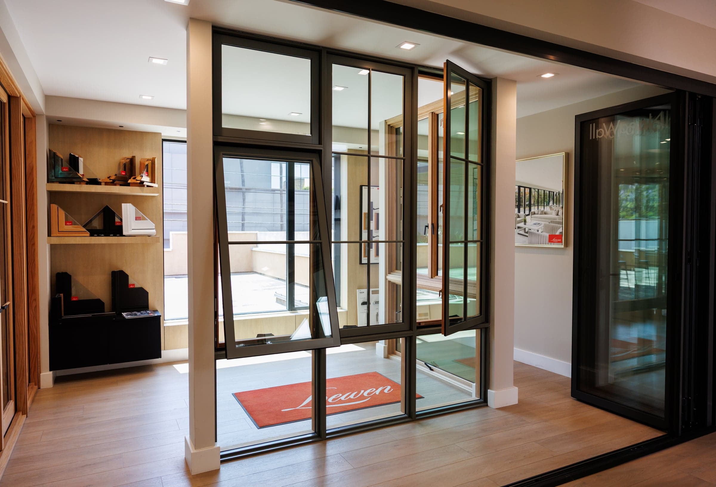 Loewen steel-frame hinged door display with warm wood shelving and material library